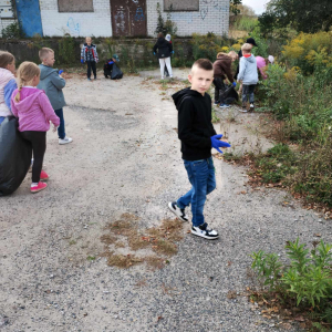 Uczniowie sprzataja okolicę. 