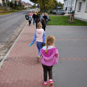 Uczniowie sprzataja okolicę. 